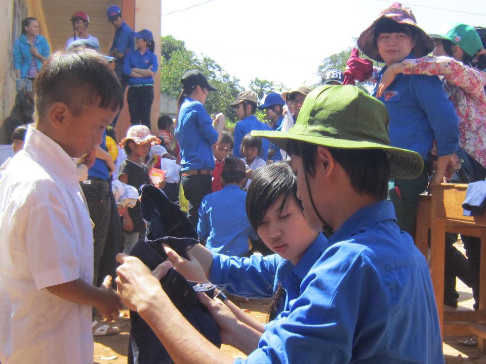 Các thành viên Nhóm “Khát vọng xanh” đang trao quần áo tặng trẻ em nghèo tại buôn Cuê, xã Băng Adrênh.