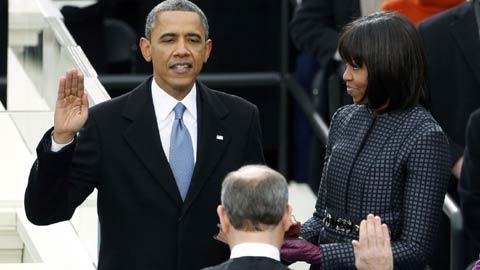 Ông Obama đặt tay phải lên hai quyển kinh thánh trên tay Đệ nhất Phu nhân Michelle và chính thức tuyên thệ nhậm chức tổng thống Mỹ nhiệm kỳ thứ hai. Ảnh: AFP