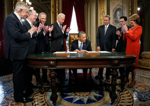 Obama ký văn bản đầu tiên trong nhiệm kỳ thứ hai tại Nhà Trắng trong tiếng vỗ tay của các quan chức cấp cao.