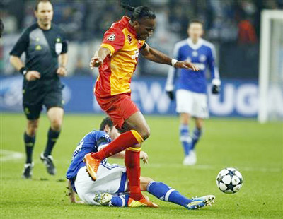 Tiền đạo Didier Drogba (Galatasaray) vượt qua sự truy cản của hậu vệ Marco Hoeger bên phía Schalke