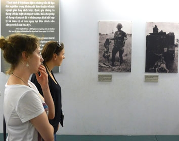 Nhiều  du khách đứng  lặng trước những  tấm ảnh ghi lại  tội ác  của  chiến tranh.