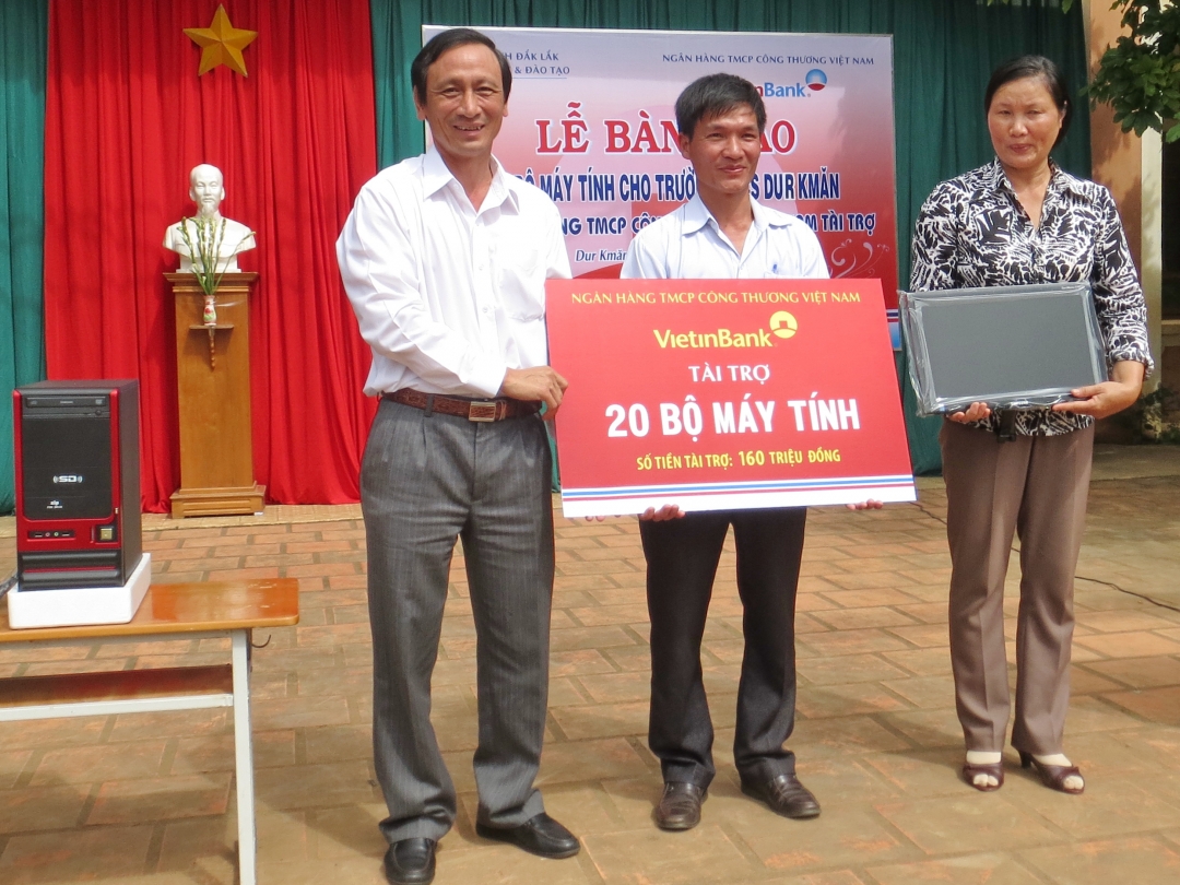 Ông Nguyễn Văn Hòa (trái), Giám đốc Vietinbank Dak Lak trao 20 bộ máy tính tặng đại diện nhà trường