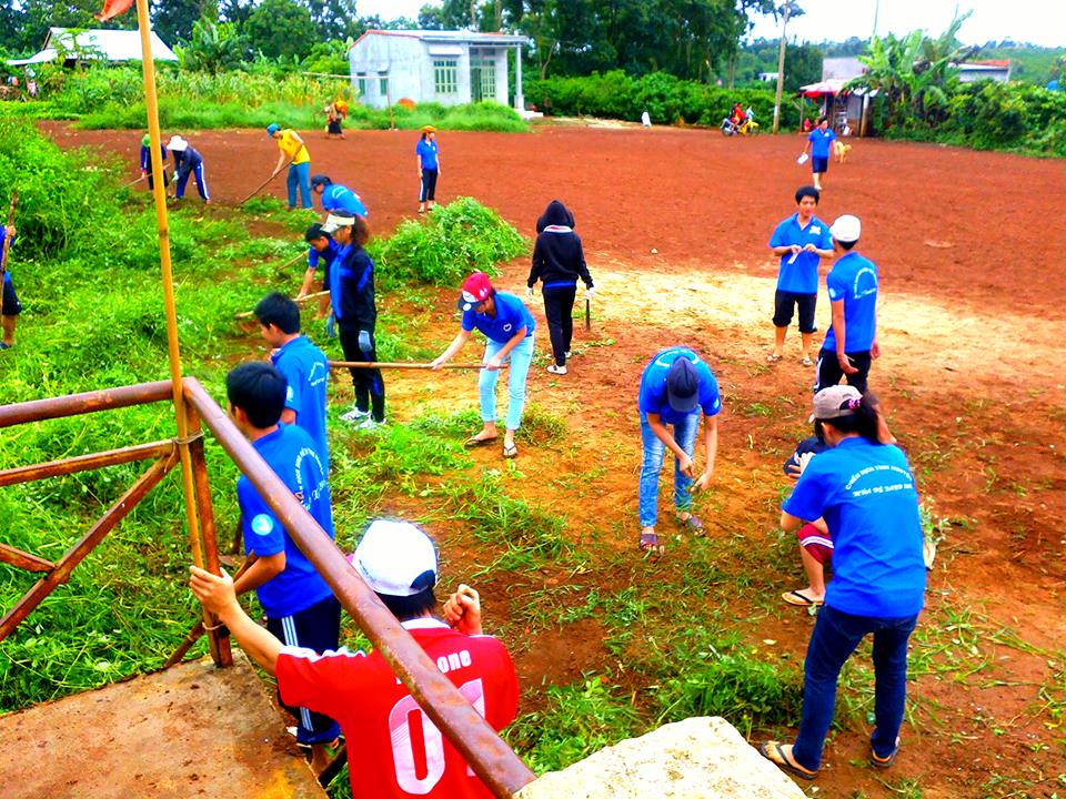 Thanh niên tình nguyện Trường Đại học Thể dục Thể thao tham gia làm sân bóng chuyền tại xã Ea Toh (Krông Năng).