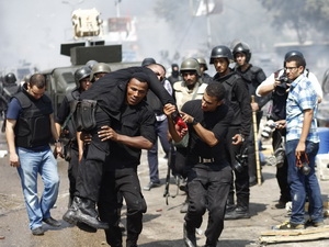 Cảnh sát Ai Cập dìu một đồng đội bị thương trong cuộc xung đột
