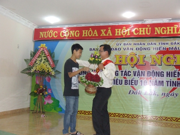 Em Đỗ Minh Cường, bệnh nhân Thalassemia, tặng hoa anh Mai Tiến Hùng, một trong những tình nguyện viên tích cực trong phong trào hiến máu.