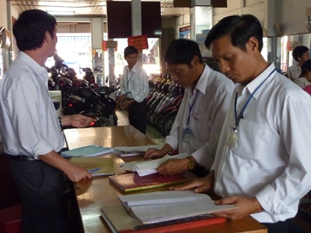 Cán bộ Chi cục Thuế thị xã Buôn Hồ (bên phải) kiểm tra, hướng dẫn DN sử dụng hóa đơn