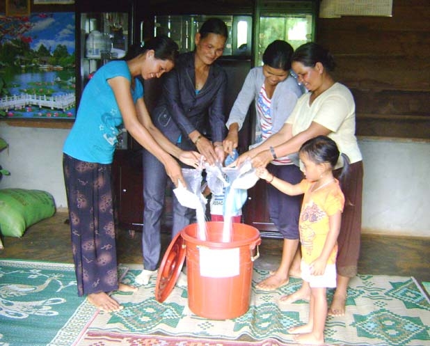 Hội viên phụ nữ chi hội buôn Huk A đóng góp gạo  xây dựng “Hũ gạo tình thương”.