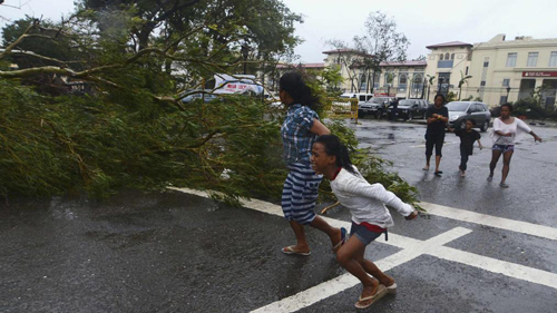 Người dân Philippines tìm nơi trú ẩn khi mưa to gió lớn quật đổ cây cối 