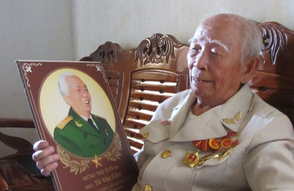 Cụ Tô Đình Cắm và tấm ảnh Đại tướng Võ Nguyên Giáp.                                                                                                                (Nguồn: Báo Thanh Niên)