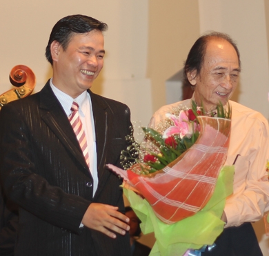Nhạc sĩ Phạm Hoàng Long (trái) nhận hoa từ nhạc sĩ Nguyễn Văn Nam  trong buổi ra mắt tác phẩm.