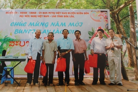 Ông Hoàng Chuyên, Chủ tịch Hội Hữu nghị Việt – Lào tỉnh Dak Lak (ngoài cùng bên phải) chúc tết Punbimay (Tết cổ truyền của Lào) tại xã Krông Na, huyện Buôn Đôn.