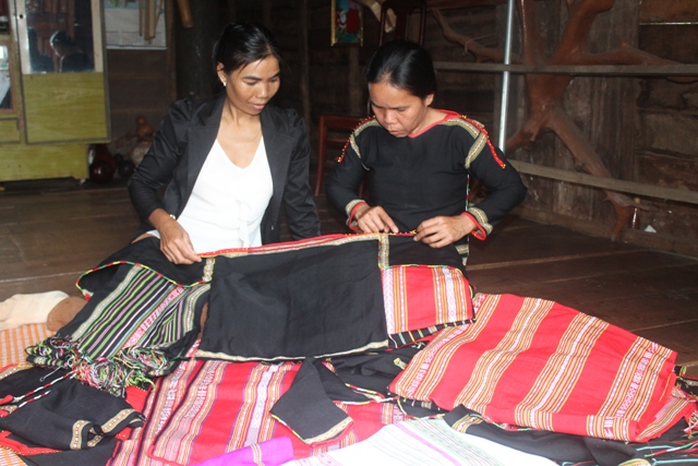 Chị H’Juen (bên phải) đang hướng dẫn cách tạo những hoa văn, họa tiết trên chiếc áo thổ cẩm truyền thống cho học viên .
