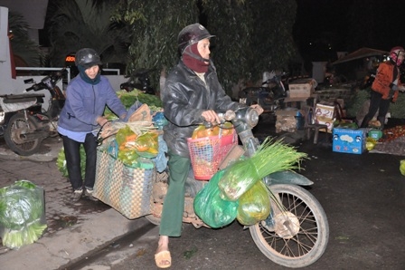 Một đôi vọ chồng già đang chuyển hàng hóa mua được tại chợ về bán lại