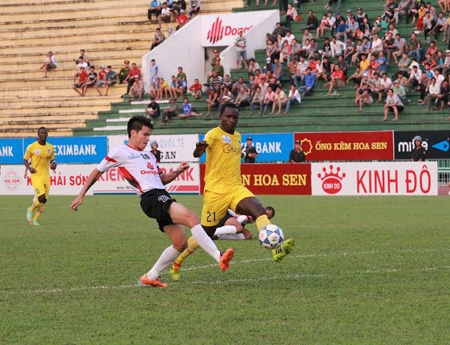 Quang Thanh vất vả ngăn cản cầu thủ tấn công của đội khách
