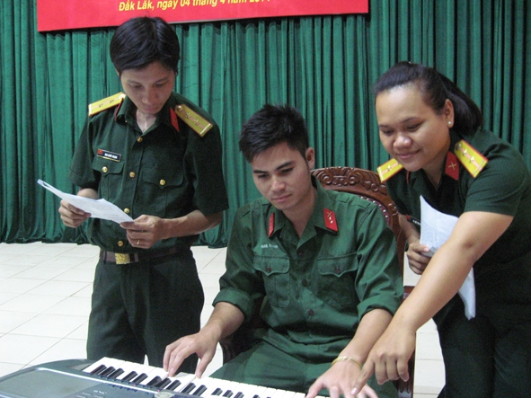 Binh nhất  Y Nan Êban đệm đàn  cho các thành viên trong đội luyện tập  các tiết mục văn nghệ.