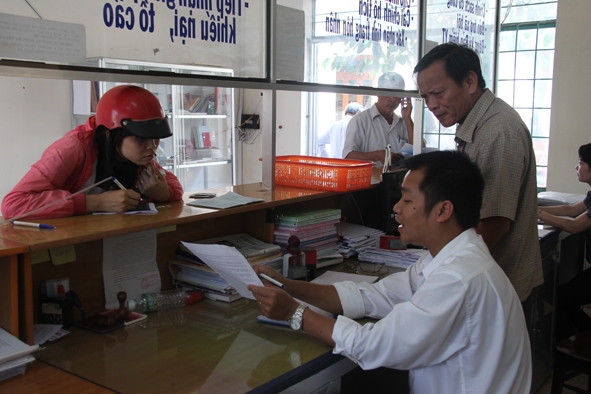 Nhân viên bộ phận một cửa phường Ea Tam (TP. Buôn Ma Thuột) tận tình hướng dẫn người dân khi đến chứng thực giấy tờ. 