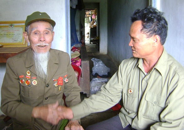 Ông Lê Ngọc Sơn (bên trái) chia sẻ niềm tự hào của người lính Điện Biên với hội viên CCB xã Cư Ni.