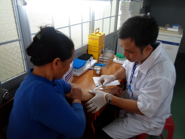 Kỹ thuật viên Tiến lấy máu xét nghiệm cho bệnh nhân.