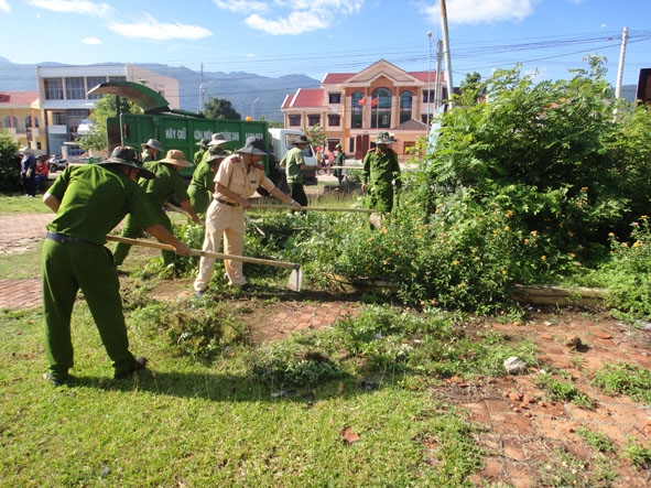 Đoàn viên Công an huyện Krông Bông dọn cỏ khu vực  hoa viên thị trấn Krông Kmar.