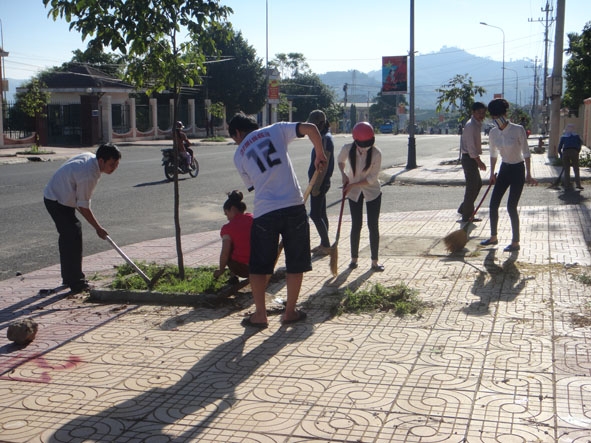 Đoàn viên làm vệ sinh môi trường trên vỉa hè của một tuyến phố