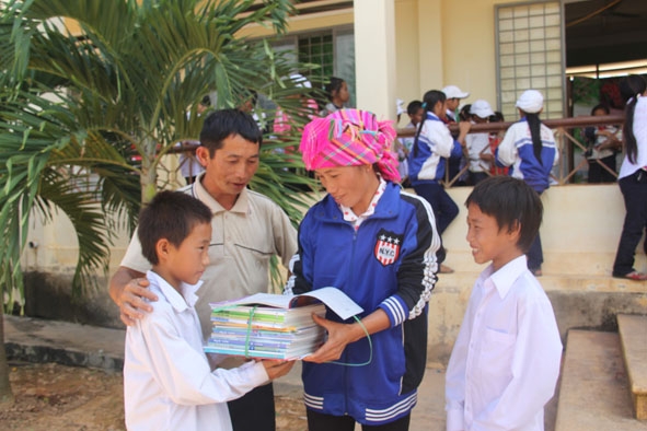 Niềm vui của bố con ông Triệu Văn Bình khi nhận sách giáo khoa,  vở viết và dụng cụ học tập năm học mới.