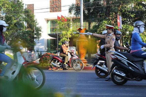 Nữ CSGT hướng dẫn các phương tiện đi đúng làn đường                trên đường Nguyễn Tất Thành (TP. Buôn Ma Thuột).        Ảnh: Hoàng Gia