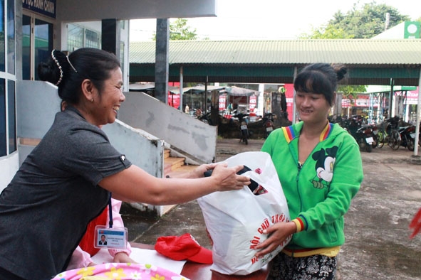 Chị Nguyễn Thị Hạnh, Chủ tịch Hội Chữ thập đỏ huyện Cư M'gar trao tặng áo quần cho người nghèo.