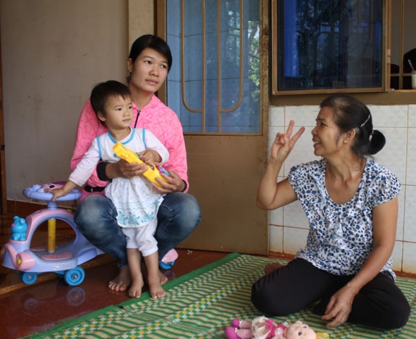 Bà Nguyễn Thị Minh (bìa phải) vui vẻ bên cạnh con dâu và cháu nội. 