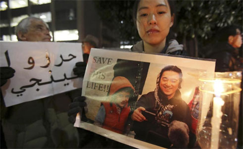 ột người dân Nhật Bảncầm bức ảnh của nhà báo Kenji Goto trong một cuộc tuần hành phía trước dinh Thủ tướng tại Tokyo (Ảnh AP)