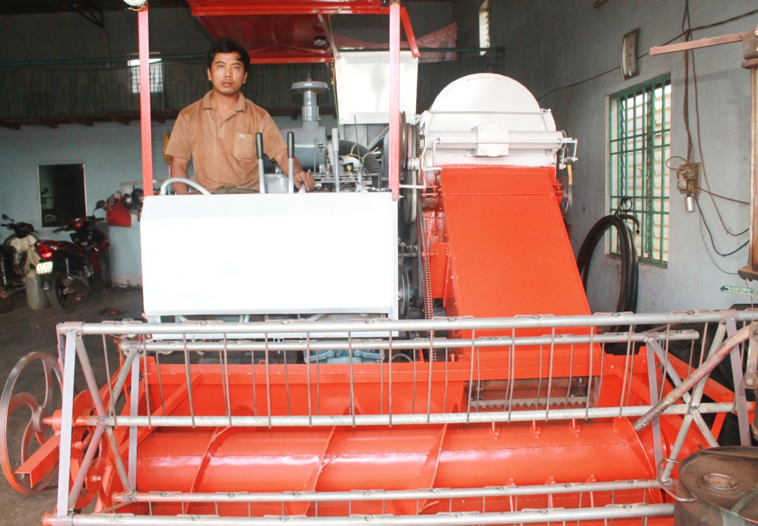Anh Nguyễn Văn Hải đang vận hành chiếc máy gặt lúa liên hợp đa năng do mình chế tạo