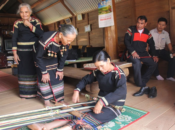 Bà H’Lil Mlô (thứ 2 từ trái sang) đang truyền dạy nghề dệt thổ cẩm cho chị em buôn Tring 2 (phường An Lạc, thị xã Buôn Hồ).