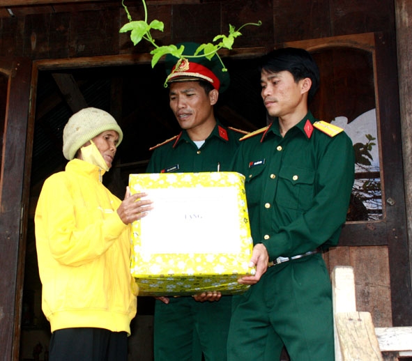 Thượng úy Rahlan Huỳnh (giữa) cùng đồng đội trao quà tặng gia đình khó khăn ở xã Ea Drông (thị xã Buôn Hồ).