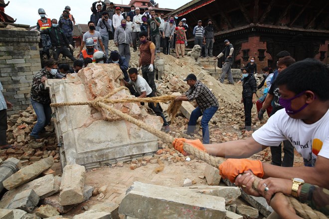 Lực lượng cứu hộ và người dân Nepal làm việc tại khu vực đền cổ Mahadev Mandir ở quảng trường Durbar bị phá hủy sau trận động đất. (Nguồn: AFP/TTXVN)