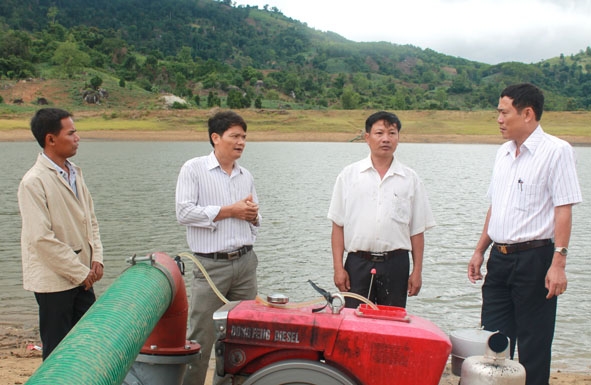 Bí thư Huyện ủy M’Đrắk Võ Văn Cảnh (bìa phải) kiểm tra  hiện trạng cấp nước của Đập Ea Má (xã Cư M’ta).
