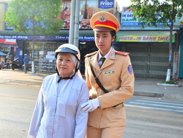 Chiến sĩ CSGT - Công an tỉnh hướng dẫn người già qua đường an toàn.