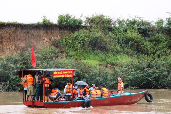 Người dân qua sông trên con đò của Phòng CSGT - Công an tỉnh tặng.