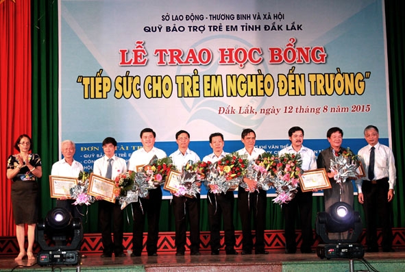Lãnh đạo Bộ LĐTBXH và UBND tỉnh Đắk Lắk tặng hoa và giấy chứng nhận Tấm lòng vàng cho các đơn vị tài trợ.