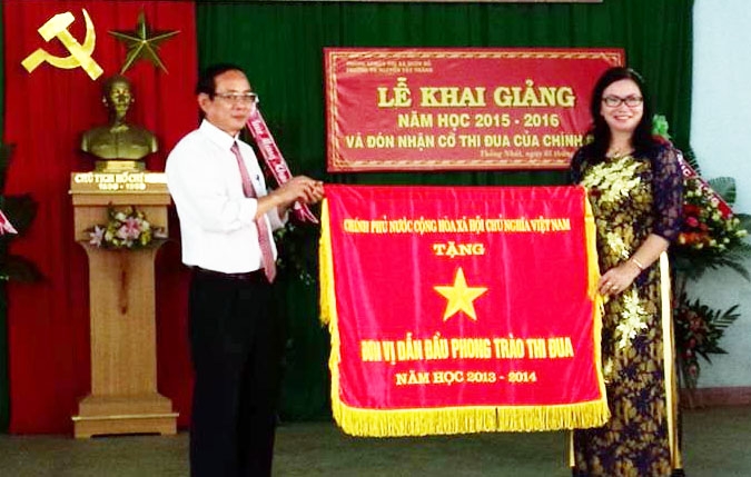 Lãnh đạo TX.Buôn Hồ trao Cờ thi đua cho Trường Tiểu học Nguyễn Tất Thành. Ảnh: Ninh Trang