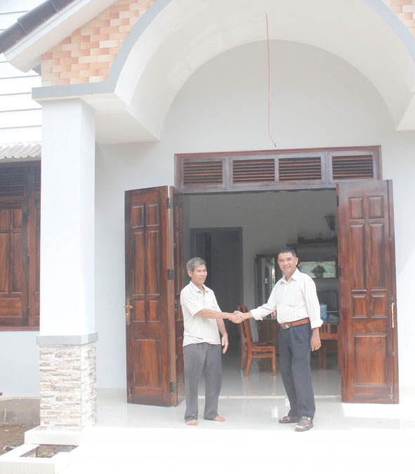 Ông Nguyễn Xuân Thành, trú tại thôn 10, xã Ea Tiêu, huyện Cư Kuin (bên trái) vui mừng trước  căn nhà mới xây của  gia đình.