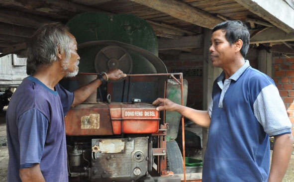 Ông Y Phu Êung (phải) chia sẻ kinh nghiệm sản xuất với người dân trong buôn.