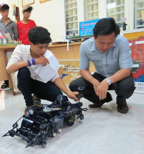 Mô hình “Máy tái chế nông nghiệp”  của học sinh Phan Ngọc Linh (bên trái) Trường THCS 719, huyện Krông Pắc.
