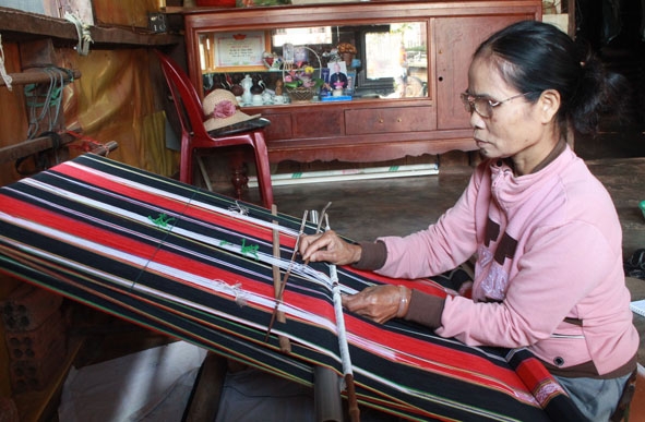 Amí San đang hoàn thiện tấm khăn thổ cẩm  để giao cho khách hàng.