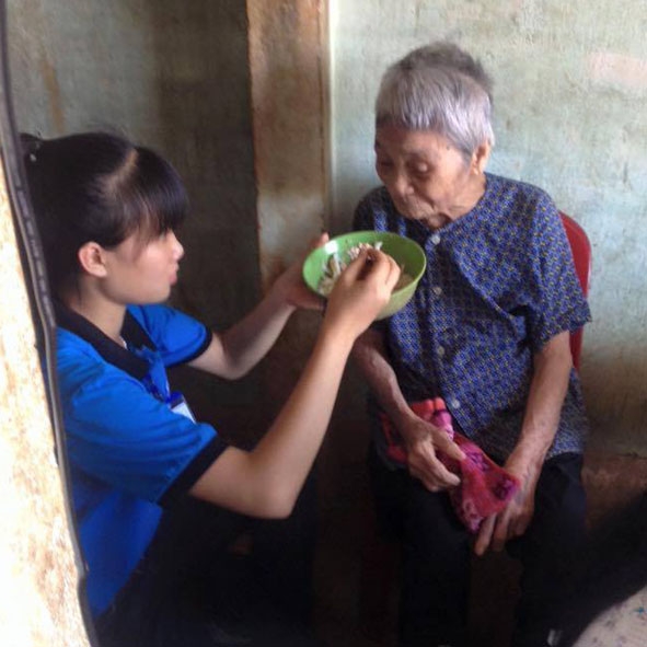 Thành viên đội CTXH huyện Cư M'gar đến nấu cơm, dọn dẹp nhà cửa, chăm sóc bà Nguyễn Thị Tất (93 tuổi, trú tại thôn Tân Lập,  xã Ea Kpam).