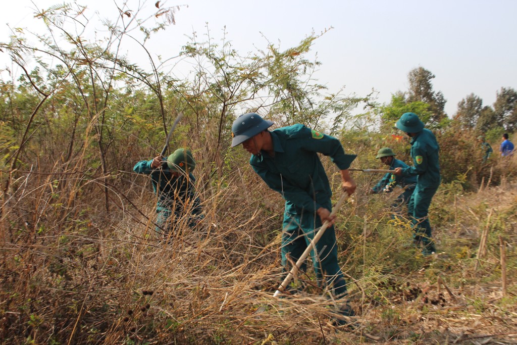 Lực lượng dân quân tự vệ giúp dân phát quang bụi rậm