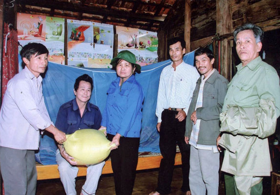 Các thành viên tổ đoàn kết khối 14, thị trấn Phước An (huyện Krông Pắc) tặng gạo gia đình  có hoàn cảnh khó khăn.