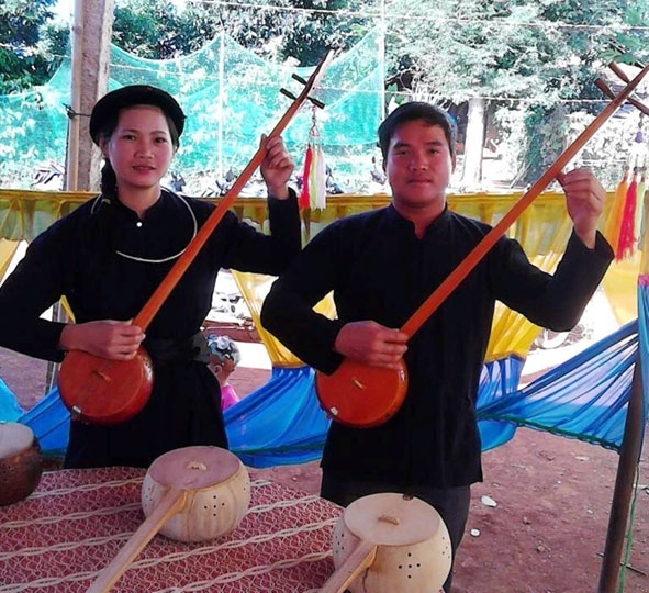 Anh Tân và vợ đang biểu diễn bằng cây đàn tính do chính mình chế tác.