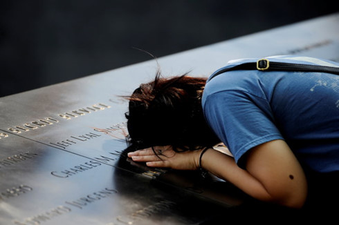 Một phụ nữ Mỹ đến tưởng nhớ người thân ở khu tưởng niệm khắc tên các nạn nhân hôm 10-9. (Ảnh: Reuters).