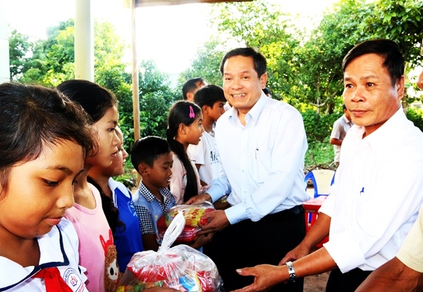 Phó Cục trưởng Cục Thuế tỉnh Ngô Việt Hồng trao quà cho các cháu thiếu nhi tại buôn