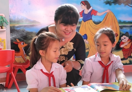 Phó Chủ tịch UBND tỉnh H'Yim Kđoh cùng các em học sinh đọc sách trong Thư viện thân thiện