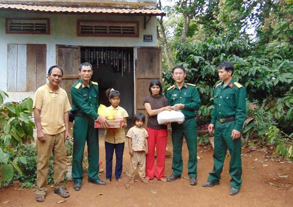 Lãnh đạo Ban CHQS huyện Cư M’gar tặng quà cho hộ nghèo.  Ảnh: T. Hùng